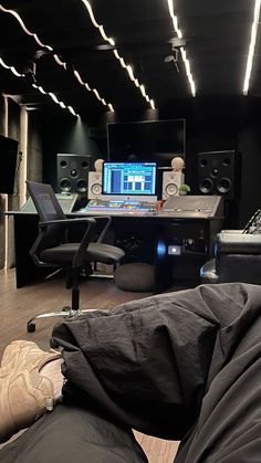 a person laying on the floor in front of a desk with a computer and sound equipment