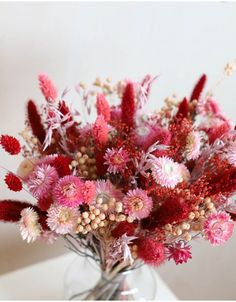 a vase filled with lots of red and white flowers