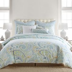 a bed with blue and white comforters in a room