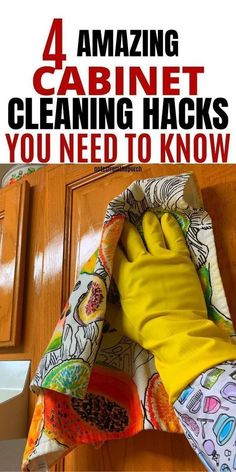 a person wearing yellow rubber gloves and cleaning the kitchen cabinets with a cloth on it