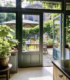 an open door leading to a patio with potted plants