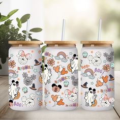 three mickey mouse tumblers with straws on them