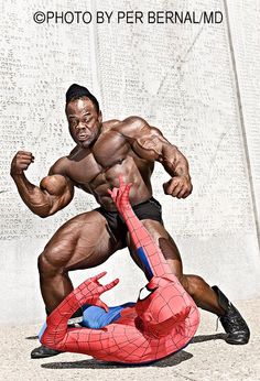 an image of a bodybuilding man on the ground with a spider - man in front of him