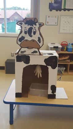 a cardboard cow is sitting in the middle of a room