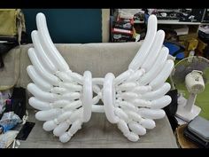 an inflatable chair with wings on it is sitting next to a fan and other items