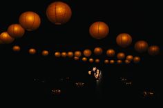 a couple kissing under lanterns in the dark