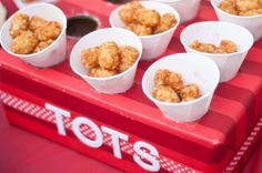 there are many small cups with food in them on the red tableclothed tray