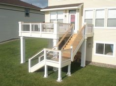 a house with a deck and stairs in the front yard