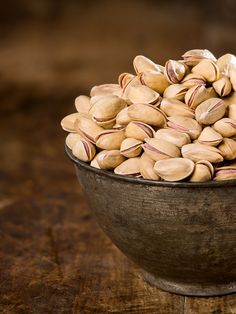 a wooden bowl filled with nuts on top of a table