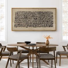 a dining room table with four chairs and a large painting on the wall above it