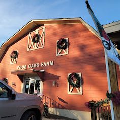 a car parked in front of a red building with wreaths on the windows and door