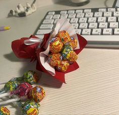 there is a bouquet of candy in front of a keyboard and some pencils on the desk