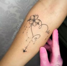 a woman's arm with a flower on it and an arrow in the middle