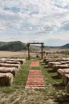 an outdoor ceremony set up in the middle of a field with hay bales on it