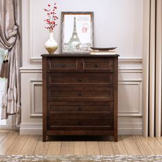 a wooden dresser sitting in front of a window with curtains on either side and a framed picture above it