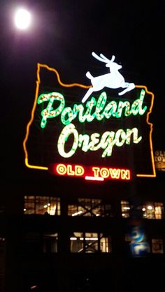 the sign for portland oregon old town is lit up at night with lights on it