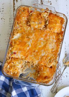 a casserole dish with meat and cheese in it on a blue checkered cloth