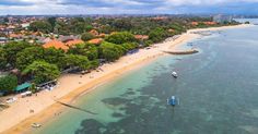 an aerial view of a beach with boats in the water and houses on the shore