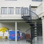 an outside view of a house with a spiral stair case and inflatable pool