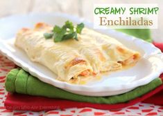 an enchilada on a white plate with cilantro