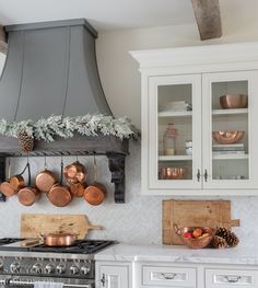 a stove top oven sitting inside of a kitchen next to white cabinets and counter tops