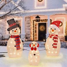 three lighted snowmen in front of a house