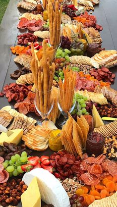 a long table filled with lots of different types of cheeses and crackers on it