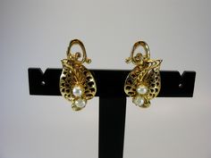 earrings, filigree  jewellery, gold, leave, clip-on, pearls, earrings, gold earrings, wedding, clip-on earrings, filigree earrings, vintage jewellery --------------------------- We are offering this Pair gold tone leaves Clip-On Earrings. Both earrings have a faux pearl embellishment. Each measures 1-3/16" (3cm) long by 5/8" (1.5cm) wide. Very good vintage condition. Please see the pictures for more details. For adult use only - embellishments may have small or pointy parts. Actual colors may sl Elegant Filigree Clip-on Earrings For Wedding, Yellow Gold Clip-on Earrings For Wedding, Elegant Wedding Clip-on Filigree Earrings, Wedding Yellow Gold Clip-on Earrings, Gold Clip-on Bridal Earrings For Evening, Pearls Earrings Gold, Filigree Jewellery, Schmuck Gold, Pearl Embellishment