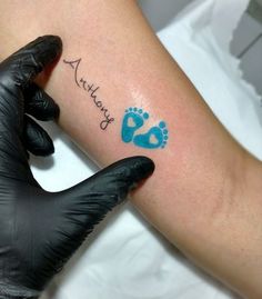 a person with a tattoo on their arm and the word baby written in blue ink