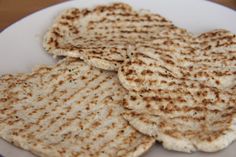 several flatbreads are arranged on a white plate