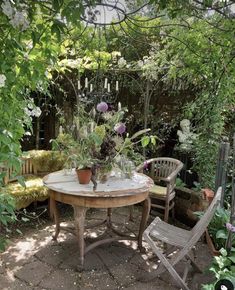 a table and chairs in a small garden