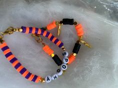 two bracelets with letters on them sitting on some type of ice floet