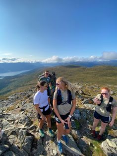 three people standing on top of a rocky hill