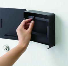 a person's hand is pressing the latch on a black box