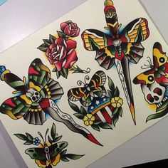 an assortment of tattoos on a sheet of paper with scissors, roses and butterfly tattoo designs