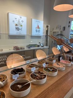 a counter filled with lots of different types of desserts and pastries in bowls