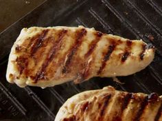 two pieces of meat cooking on an outdoor grill