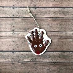 an ornament shaped like a hand with sprinkles and eyes on it