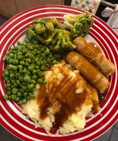 a red and white plate topped with meat, mashed potatoes, green peas and broccoli