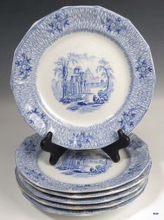 four blue and white plates stacked on top of each other