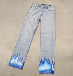 "1 of 1 \"Eternal Blue Flames\" up-cycled vintage denim jeans Size: 29x30 Tag: eflannery.art Comes as is, hand painted design on up-cycled vintage jeans  Measurements are taken in the photos  Message for additional information on the piece or preferred shipping prices  All items ship within 1-3 business days of purchase  Items are preowned unless otherwise stated  Always happy to do discounts on bundles! Happy hunting!!" Blue Rigid Denim Pants For Summer, Blue Reworked Jeans For Streetwear, Upcycled Denim Blue Jeans For Spring, Spring Upcycled Denim Blue Jeans, Upcycled Blue Bottoms For Spring, Casual Upcycled Blue Jeans, Reworked Straight Leg Blue Jeans, Blue Upcycled Recycled Denim Jeans, Upcycled Blue Recycled Denim Jeans