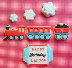 a birthday cake and cookies are arranged on a table