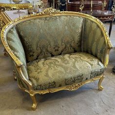 an ornately decorated couch sits in the middle of a room filled with antique furniture