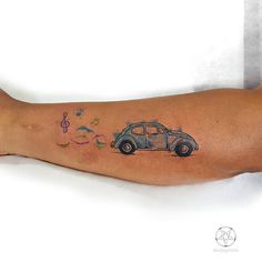 a person with a tattoo on their arm has a car and music notes coming out of it