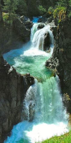 the water is blue and green as it flows through the rocks in the river bed