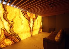 a couch sitting in front of a wall covered in yellow and brown marbled paper