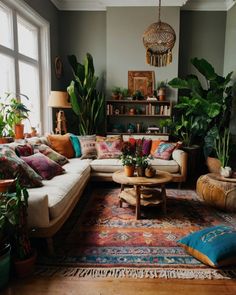 a living room filled with lots of furniture and plants