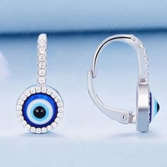 These Turkish evil eye dangle drop earrings are crafted from 925 sterling silver and feature cubic zirconia stones set in an ornate evil eye design. The blue enamel color adds to the protective powers of these stylish earrings. Offering protection from envy with both fashion and function, they are perfect for everyday wear or for special occasions. The latch back closure ensures they stay comfortably in place all "evil eye" long, while the sterling silver offers lasting durability. Slip these ev Sterling Silver Evil Eye Teardrop Jewelry, Sterling Silver Teardrop Evil Eye Jewelry, Silver Dangle Jewelry With Diamond Eyes, Sterling Silver Dangle Evil Eye Jewelry, Fine Jewelry Silver Earrings With Diamond Eyes, Silver Earrings With Diamond Eyes Fine Jewelry, Sterling Silver Evil Eye Dangle Earrings, Silver Round Evil Eye Earrings, Evil Eye Cubic Zirconia Jewelry