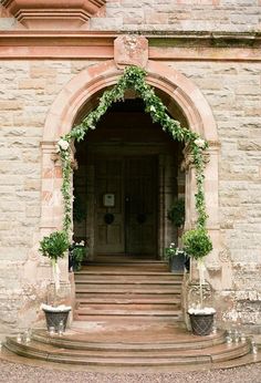 the entrance to an old building with potted plants