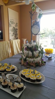 a table topped with lots of cupcakes covered in frosting and toppings